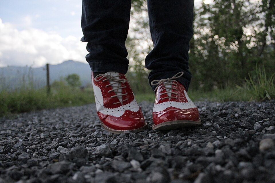 Red shoes worn outdoors on gravel