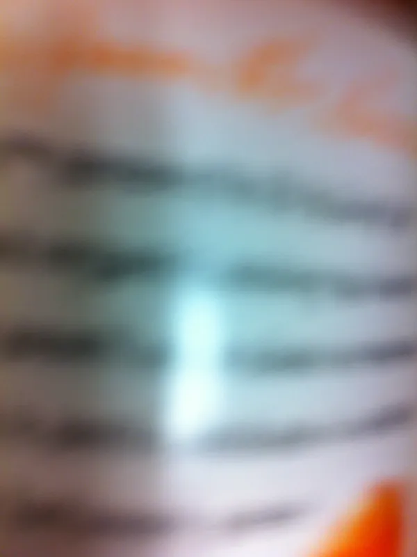 A completely blurred close-up of a bottle label with a few dark stripes of unreadable text and an orange edge