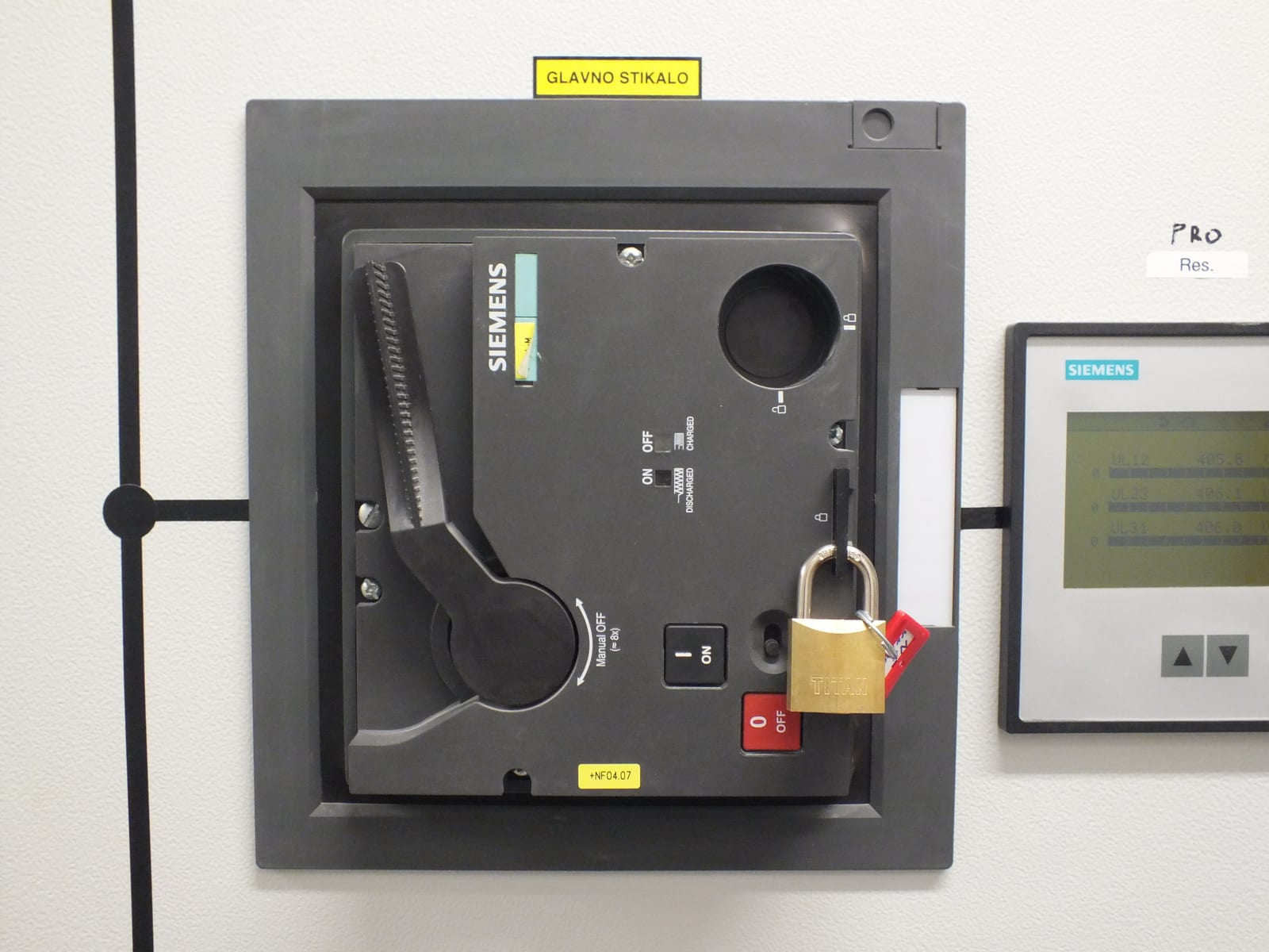 Siemens main switch in a panel door, secured with a padlock and a warning tag